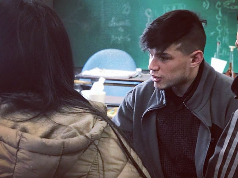 Federico Garberi explicando a una estudiante frente al pizarrón, en el aula.